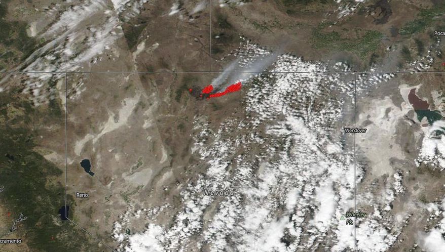 This July 8, 2018 satellite image from NASA's Suomi NPP satellite shows a wildfire, shown in red, also known as the Martin Fire, in Nevada, and smoke reaching to Idaho. The NASA satellite captured infrared imaging of the fire that has burned nearly 700 square miles (1,813 sq. kilometers) of mostly sage brush, grasses and rangeland, an area almost half the size of the state of Rhode Island, according to the NASA/Goddard Space Flight Center. (NASA via AP)