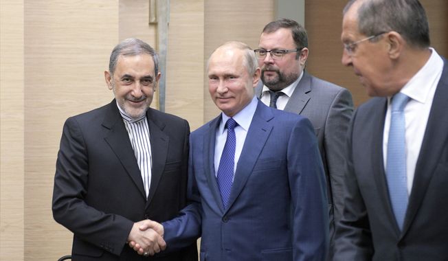 Russian President Vladimir Putin, center, shakes hands with Ali Akbar Velayati, a senior adviser to Iran&#x27;s Supreme Leader Ayatollah Ali Khamenei, as Russian Foreign Minister Sergey Lavrov, stands at right, at Novo-Ograyovo outside in Moscow, Russia, Thursday, July 12, 2018. Putin has received the Iranian leader&#x27;s top adviser hours after conferring with the Israeli prime minister about Iran&#x27;s presence in Syria. (Alexei Druzhinin, Sputnik, Kremlin Pool Photo via AP)