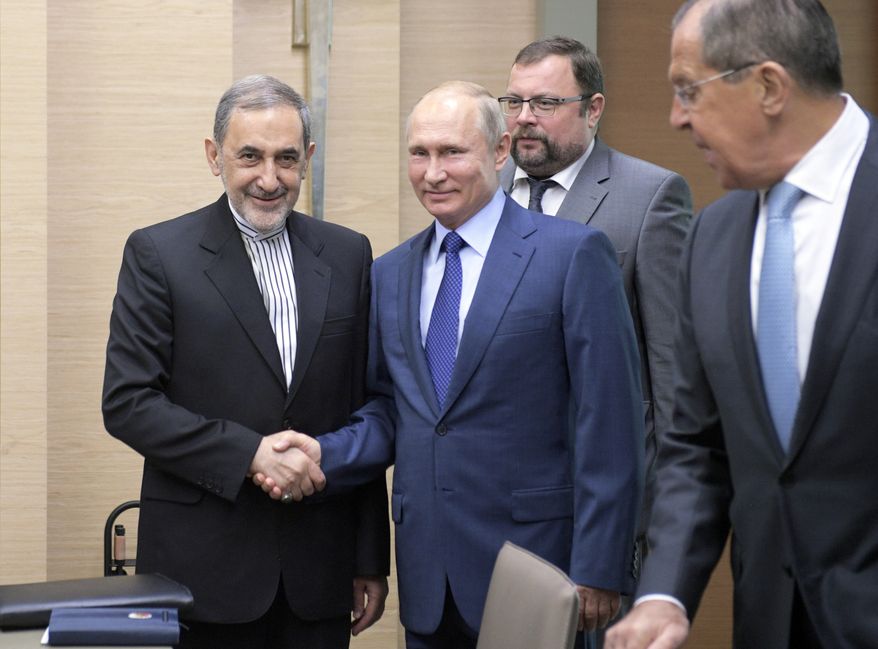 Russian President Vladimir Putin, center, shakes hands with Ali Akbar Velayati, a senior adviser to Iran&#39;s Supreme Leader Ayatollah Ali Khamenei, as Russian Foreign Minister Sergey Lavrov, stands at right, at Novo-Ograyovo outside in Moscow, Russia, Thursday, July 12, 2018. Putin has received the Iranian leader&#39;s top adviser hours after conferring with the Israeli prime minister about Iran&#39;s presence in Syria. (Alexei Druzhinin, Sputnik, Kremlin Pool Photo via AP)