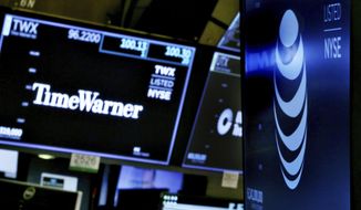 FILE - In this June 13, 2018, file photo, the logos for Time Warner and AT&amp;amp;T appear above alternate trading posts on the floor of the New York Stock Exchange. The Justice Department said in a one-sentence document Thursday, July 12, 2018, it is appealing the ruling last month by U.S. District Judge Richard Leon, which blessed one of the biggest media deals ever following a landmark antitrust trial. (AP Photo/Richard Drew, File)