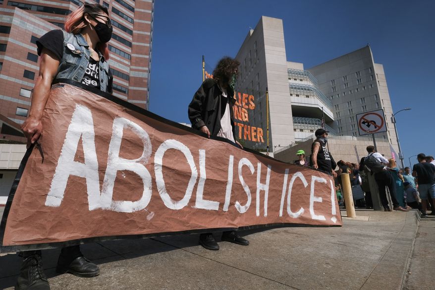 Protesters display a sign that reads &quot;Abolish ICE&quot; during a rally in front of the Immigration and Customs Enforcement facility in downtown Los Angeles on Monday, July 2, 2018. Protesters who were blocking the entrance to an Immigration and Customs Enforcement facility in downtown Los Angeles have been led away in handcuffs. A group of 17 protesters sat down in the street, blocking the entrance to the facility Monday morning. The protesters, including faith and community leaders, locked arms and chanted, &quot;Shut down ICE!&quot; (AP Photo/Richard Vogel)