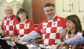 Croatia&#x27;s Prime Minister Andrej Plenkovic, center, sits between ministers wearing Croatian national soccer team jerseys during during a government session in Zagreb, Croatia, Thursday, July 12, 2018, a day after Croatia qualified in finals at the soccer World Cup. (AP Photo)