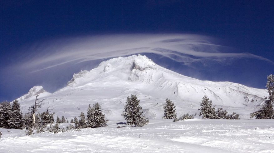 FILE - In this Dec. 13, 2009, file photo, a cloud forms over Mount Hood as seen from Government Camp, Ore.An Oregon official said a climber being rescued Friday, July 13, 2018, from Mount Hood had gone to the summit because he wanted to end his life there and that the man changed his mind when he got to the top. (AP Photo/Don Ryan, File)
