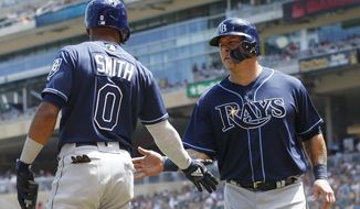 Tampa Bay Rays&#x27; Wilson Ramos, right is greeted by Malex Smith after scoring on a double by Carlos Gomez off Minnesota Twins pitcher Jose Berrios in the fourth inning of a baseball game Saturday, July 14, 2018, in Minneapolis. (AP Photo/Jim Mone)