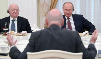Russian President Vladimir Putin, right, and First Vice President of the Russian Football Union Nikita Simonyan, left, listen to FIFA President Gianni Infantino, back to a camera, during a meeting in the Kremlin in Moscow, Russia, Friday, July 6, 2018. (Alexei Druzhinin, Sputnik, Kremlin Pool Photo via AP)
