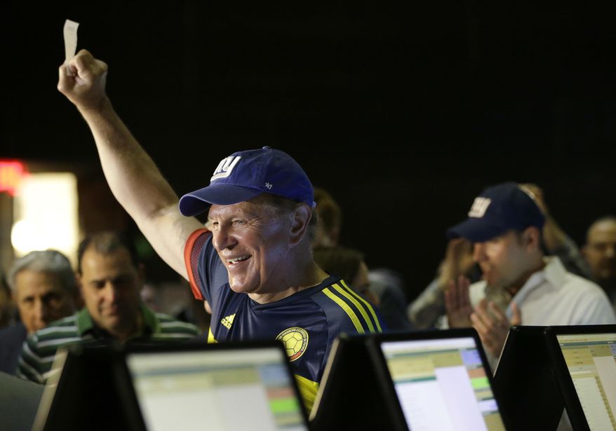 Former New Jersey Sen. Raymond Lesniak holds up a ticket after he casted the very first bet at the Meadowlands Racetrack, Saturday, July 14, 2018, in East Rutherford, N.J. Meadowlands Racetrack is the fourth sports betting outlet in New Jersey following the state's U.S. Supreme Court victory in a case that cleared the way for all 50 states to legalize sports betting. (AP Photo/Julio Cortez)