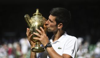 Novak Djokovic of Serbia kisses the trophy after defeating Kevin Anderson of South Africa in the men&#39;s singles final match at the Wimbledon Tennis Championships in London, Sunday July 15, 2018. (Neil Hall/Pool via AP)