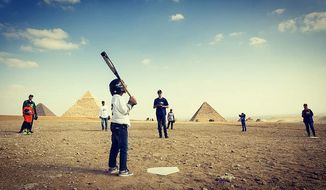 Children and adults playing baseball with iconic Egyptian pyramids in the background. Archaeologists seem to think a form of baseball, America&#39;s pastime, existed in Egypt 2,500 year ago. (Photo courtesy of Because Baseball)