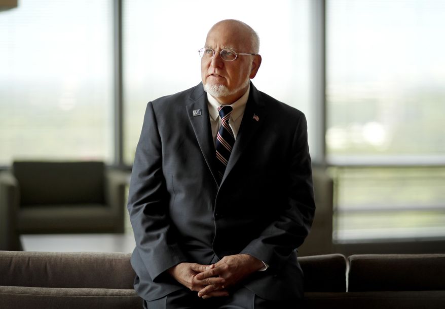 FILE - In this June 28, 2018, file photo, Dr. Robert Redfield Jr., director of the Centers for Disease Control and Prevention, poses at the agency's headquarters in Atlanta. The new head of the nation’s top public health agency says the U.S. opioid will be one of his main priorities, and it turns out there is a personal reason. (AP Photo/David Goldman, File)