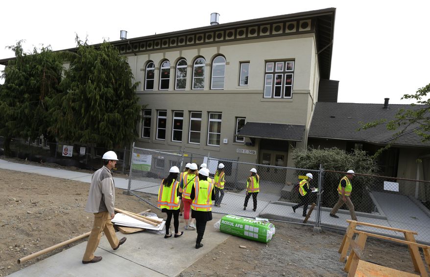 FILE - In this July 13, 2015 file photo, visitors wearing safety vests and hardhats begin a tour of the Destiny Charter Middle School in Tacoma, Wash. The school opened later in 2015. All told, the Bill and Melinda Gates Foundation has given about $25 million to the Washington State Charter Schools Association, and since 2006, philanthropists and their private foundations and charities have given almost half a billion dollars to similar groups, according to an Associated Press analysis of tax filings and Foundation Center data.(AP Photo/Ted S. Warren, file)