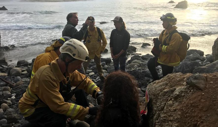 In this Friday, July 13, 2018, photo posted on the Monterey County, Calif., Sheriff&#x27;s Office Twitter feed, authorities tend to Angela Hernandez, foreground center, after she was rescued, in Morro Bay, Calif. Authorities say a couple on a camping trip came upon Hernandez, from Oregon, who had been missing since July 6, after her car went over a cliff in coastal California. (Monterey County Sheriff&#x27;s Office via AP)