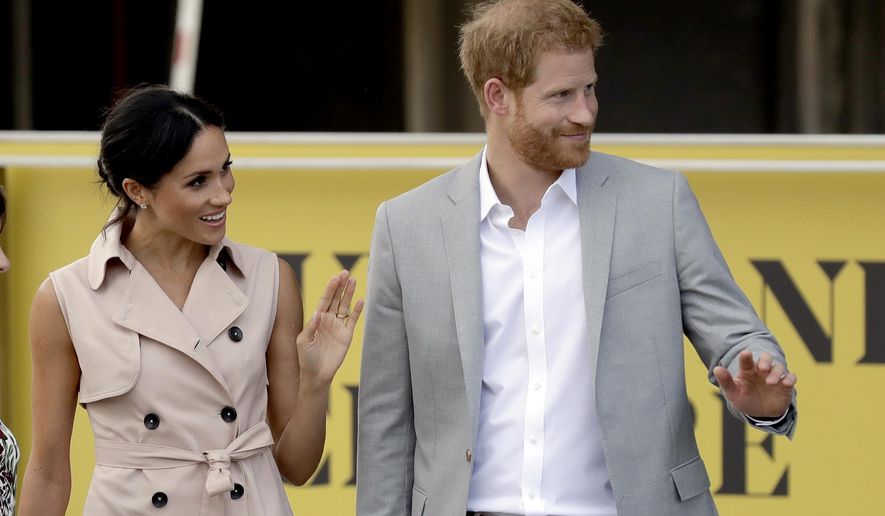 Britain's Prince Harry, right, and his wife Meghan the Duchess of Sussex wave at onlookers as they arrive for their visit to the launch of the Nelson Mandela Centenary Exhibition, marking the 100th anniversary of anti-apartheid leader's birth, at the Queen Elizabeth Hall in London, Tuesday, July 17, 2018. (AP Photo/Matt Dunham)