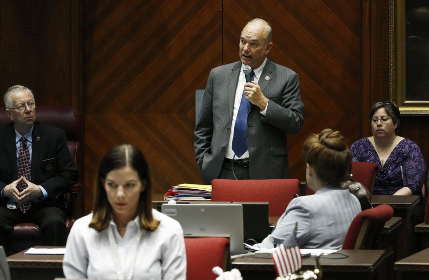 FILE - In this Jan. 9, 2018 file photo, Rep. Michelle Ugenti-Rita, foreground, R-Scottsdale, and others listen to Rep. Don Shooter, center background, R-Yuma, as he reads a statement regarding sexual harassment and other misconduct complaints made against him by Ugenti-Rita and others, as he spoke prior to Arizona House members receiving mandatory sexual harassment and other ethics issues training on the House floor at the Capitol in Phoenix. Shooter was the first state lawmaker in the country to be expelled in the #MeToo era after he was criticized for a pattern of sexually harassing women. Now he’s back, running in the state’s Republican primary for a seat in the state Senate. (AP Photo/Ross D. Franklin)