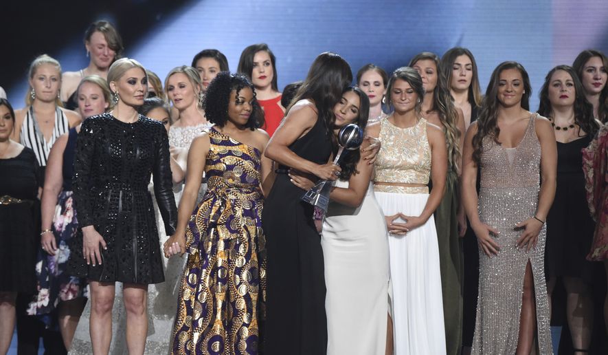 Jennifer Garner, front, embraces gymnast Aly Raisman after presenting the Arthur Ashe Award for Courage, at the ESPY Awards at Microsoft Theater on Wednesday, July 18, 2018, in Los Angeles. Holding hands in front left are former gymnast Sarah Klein and former Michigan State softball player Tiffany Thomas Lopez. More than 140 survivors of sexual abuse by a former team doctor for USA Gymnastics and Michigan State University joined hands on stage to be honored with the award. (Photo by Phil McCarten/Invision/AP)