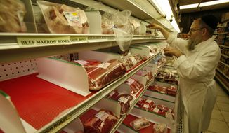 Rabbi Moishe Silverman stocks liver in a partially empty meat display at South Florida Kosher, a butcher shop in North Miami Beach, Fla., Tuesday, Nov. 25, 2008. (AP Photo/Wilfredo Lee)