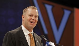 RETRANSMISSION TO CORRECT SCHOOL TO VIRGINIA - Virginia head coach Bronco Mendenhall answers a question during a news conference at the NCAA Atlantic Coast Conference college football media day in Charlotte, N.C., Wednesday, July 18, 2018. (AP Photo/Chuck Burton) **FILE**