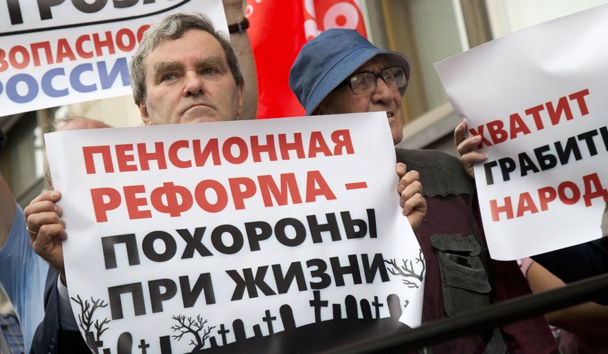 People hold posters reading from left &quot;Pension reform is a funeral in life, Stop robbing people&quot; during a protest against the government&#39;s plans to raise the retirement age, in front of the Russian State Duma, the Lower House of the Russian Parliament in Moscow, Russia, Thursday, July 19, 2018. The State Duma is voting on the bill Thursday, which would raise the age at which retirees can receive state pensions from 60 to 65 for men, and from 55 to 63 for women. (AP Photo/Alexander Zemlianichenko)