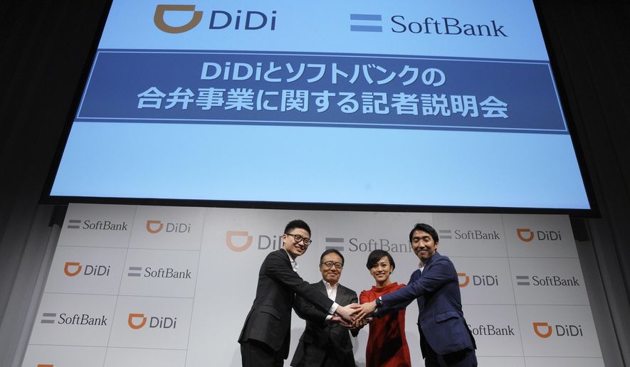 Vice President of Strategy at Didi Chuxing Stephen Zhu, left, CEO and President of Softbank Mobile Corp. Ken Miyauchi, second left, President of Didi Chuxing Jean Liu, second right, and deputy division head at Softbank Mobile Keigo Sugano shake hands during a press conference announcing their joint venture in Tokyo Thursday, July 19, 2018. (AP Photo/Eugene Hoshiko)