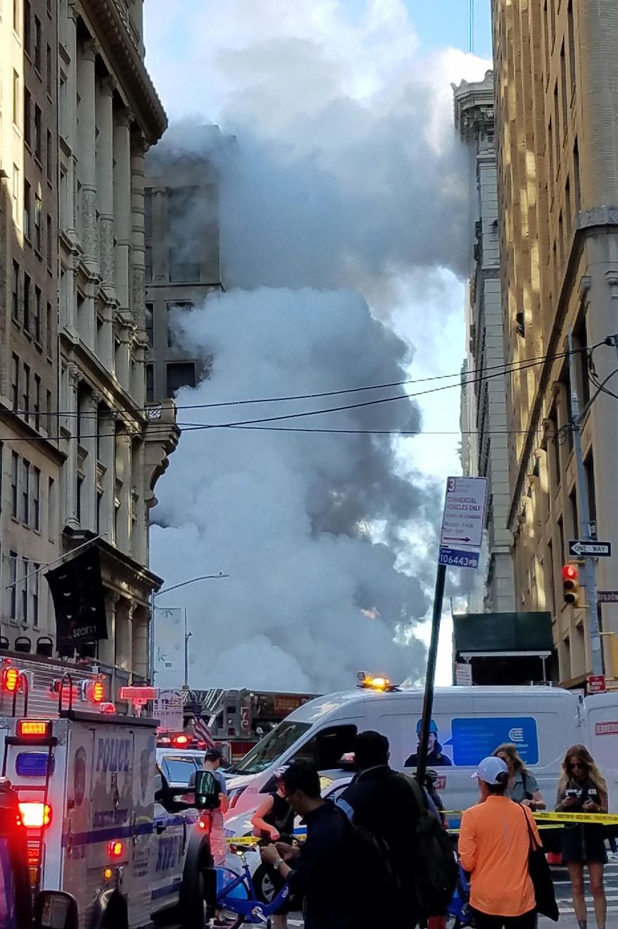 Steam billows on New York's Fifth Avenue, Thursday, July 19, 2018. A steam pipe exploded beneath Fifth Avenue in Manhattan early Thursday, sending chunks of asphalt flying, a geyser of billowing white steam stories into the air and forcing pedestrians to take cover. (AP Photo/Joyce M. Rosenberg)