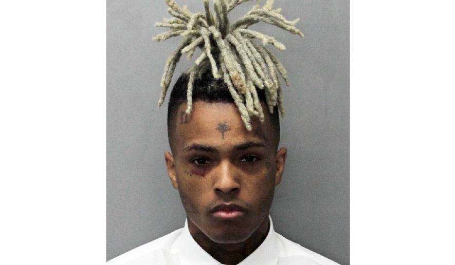 FILE - This undated photo released by the Miami-Dade Corrections & Rehabilitation Department shows rapper XXXTentacion. A Florida grand jury has indicted four men on first-degree murder and armed robbery charges in the shooting death of XXXTentacion. Court records show that the Broward County panel formally charged 24-year-old Dedrick Williams, 22-year-old Michael Boatwright, 20-year-old Trayvon Newsome and 22-year-old Robert Allen on Wednesday, July 18, 2018. (Miami-Dade Corrections & Rehabilitation Department via AP, File)