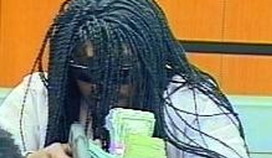 An image from video provided by the Durham Police Department shows a suspect in the robbery of a bank Wednesday, July 18, 2018, in Durham, N.C. Police say the robber shot and wounded a teller before getting away with money. (Durham Police Department via AP)