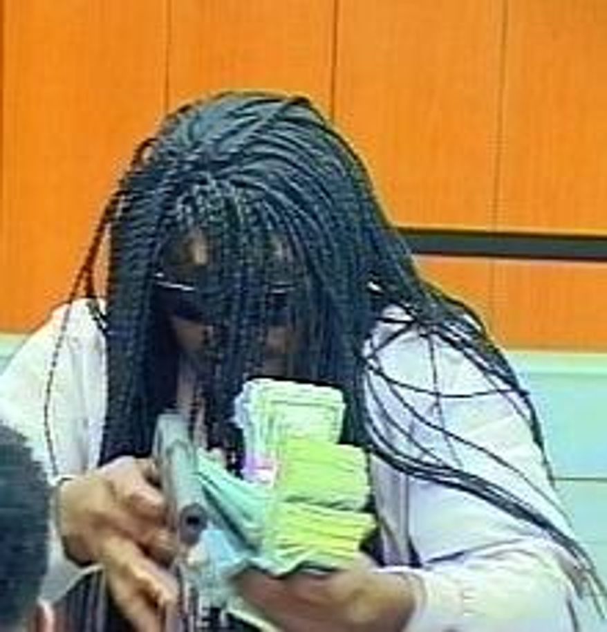 An image from video provided by the Durham Police Department shows a suspect in the robbery of a bank Wednesday, July 18, 2018, in Durham, N.C. Police say the robber shot and wounded a teller before getting away with money. (Durham Police Department via AP)