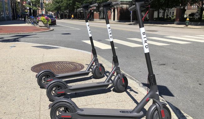Three dockless scooters stand on a sidewalk across the street from a Johnson &amp;amp; Wales University campus, Friday, July 20, 2018, in downtown Providence, R.I. A California company left its electric rental scooters on city sidewalks in Providence, and in Cambridge and Somerville, Mass., Friday without warning. (AP Photo/ Jennifer McDermott)