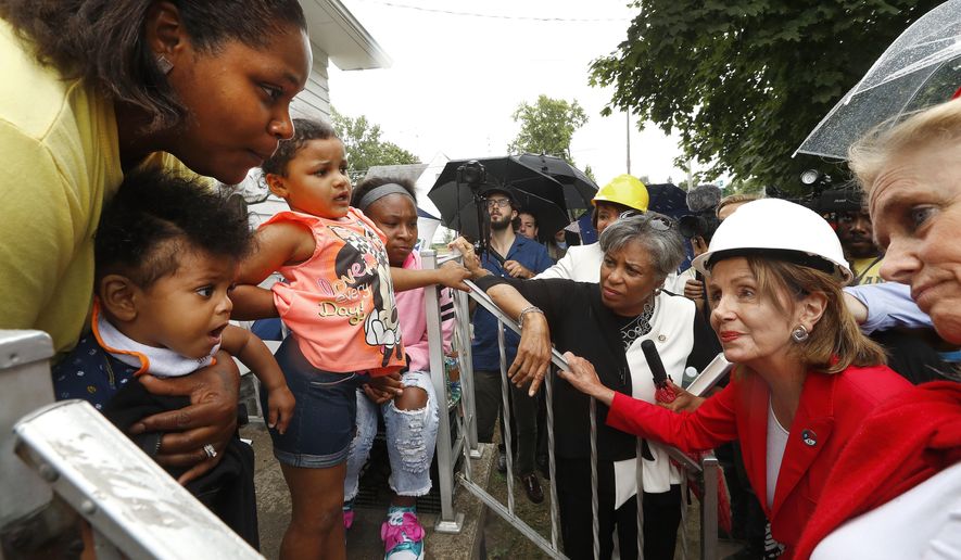 House Minority Leader Nancy Pelosi of Calif., right, talks with Deronda Jones, left, while on a congressional delegation visit to receive an update on the water crisis in Flint, Mich., Friday, July 20, 2018. (AP Photo/Paul Sancya)