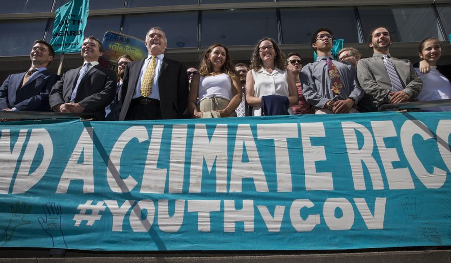 FILE - In this July 18, 2018, file photo, lawyers and youth plaintiffs lineup behind a banner after a hearing before Federal District Court Judge Ann Aiken between lawyers for the Trump Administration and the so called Climate Kids in Federal Court in Eugene, Ore. The lawsuit filed by young activists who say the government is failing to protect them from climate change is still alive. In San Francisco on Friday, July 20, 2018, the 9th U.S. Circuit Court of Appeals rejected the government's second request for an order directing a lower court to dismiss the case. (Chris Pietsch/The Register-Guard via AP, File)