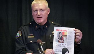 FILE - This April 24, 2015, file photo, Provo Police Chief John King holds a photo of Elizabeth Elena Laguna Salgado during a news conference in Sandy, Utah. The city of Provo has reached a $750,000 settlement with five women who say the city failed to take action to protect them from alleged sexual harassment and assault by the former police chief. (AP Photo/Rick Bowmer, File)