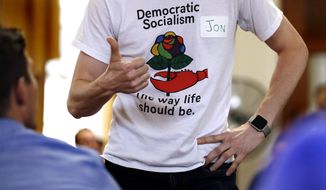 In this file photo, a man wears a T-shirt promoting democratic socialism during a gathering of the Southern Maine Democratic Socialists of America at City Hall in Portland, Maine, Monday, July 16, 2018. (AP Photo/Charles Krupa) **FILE**