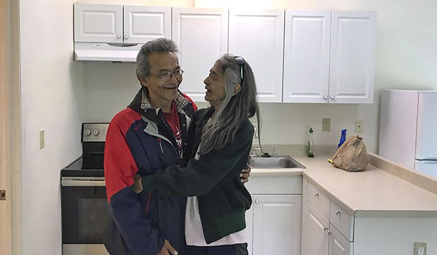In this Friday, July 13, 2018 photo, Clyde Didrickson and his wife, Charlotte, smile and hug each other in their new home in Juneau, Alaska. The couple was able to get their new home through a Tlingit Haida Regional Housing Authority grant funding program aimed to help veterans. (Gregory Philson /The Juneau Empire via AP)