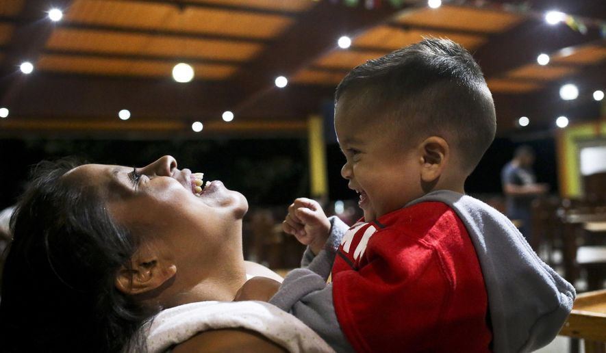 Adalicia Montecinos holds her year-old son Johan, who became a poster child for the U.S. policy of separating immigrants and their children, at a restaurant in Yojoa, Honduras, Friday, 20, 2018. Johan arrived in San Pedro Sula and was reunited with his parents on a government bus. Captured by Border Patrol agents in March, Johan's father was deported and the then 10-month-old remained at an Arizona shelter. (AP Photo/Esteban Felix)