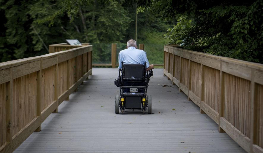 David Allgood uses a trail adapted for persons with disabilities to view a scenic overlook of the Green River at Mammoth Cave National Park in Cave City, Ky., Friday, June 22, 2018.  National Park Service accessibility chief Jeremy Buzzell says nine parks across the U.S. have received more than $10 million in federal funding to design and build accessibility projects as examples for other parks.  (AP Photo/Bryan Woolston)