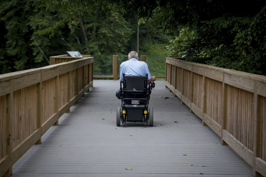 David Allgood uses a trail adapted for persons with disabilities to view a scenic overlook of the Green River at Mammoth Cave National Park in Cave City, Ky., Friday, June 22, 2018. National Park Service accessibility chief Jeremy Buzzell says nine parks across the U.S. have received more than $10 million in federal funding to design and build accessibility projects as examples for other parks. (AP Photo/Bryan Woolston)