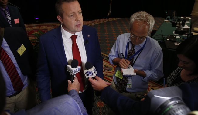 Republican Corey Stewart, left, talks to reporters after the Virginia Bar Association debate with US Sen. Tim Kaine at the Homestead in Hot Springs, Va., Saturday, July 21, 2018. (AP Photo/Steve Helber)