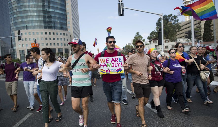 LGBT community members block a highway during a protest against a surrogate bill in Tel Aviv, Israel, Sunday, July 22, 2018. Israel&#39;s LGBT community holds a national strike Sunday after the parliament passed a law last week easing surrogate regulations but excluding gay couples having a child using a surrogate. (AP Photo/Oded Balilty)