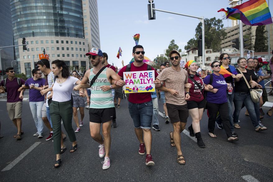 LGBT community members block a highway during a protest against a surrogate bill in Tel Aviv, Israel, Sunday, July 22, 2018. Israel's LGBT community holds a national strike Sunday after the parliament passed a law last week easing surrogate regulations but excluding gay couples having a child using a surrogate. (AP Photo/Oded Balilty)