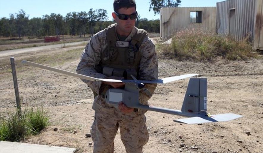 An assistant intelligence officer with Battalion Landing Team 2nd Battalion, 1st Marines, 31st Marine Expeditionary Unit, holds a RQ-11B Raven unmanned aerial vehicle in July 2012. (Image: U.S. Marine Corps, Cpl. Jonathan Wright) ** FILE **