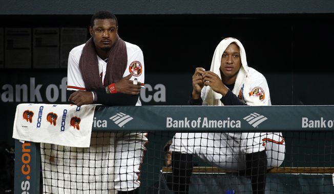 Baltimore Orioles center fielder Adam Jones, left, and second baseman Jonathan Schoop sit in the dugout in the ninth inning of a baseball game against the Boston Red Sox, Monday, July 23, 2018, in Baltimore. Boston won 5-3. (AP Photo/Patrick Semansky) **FILE**
