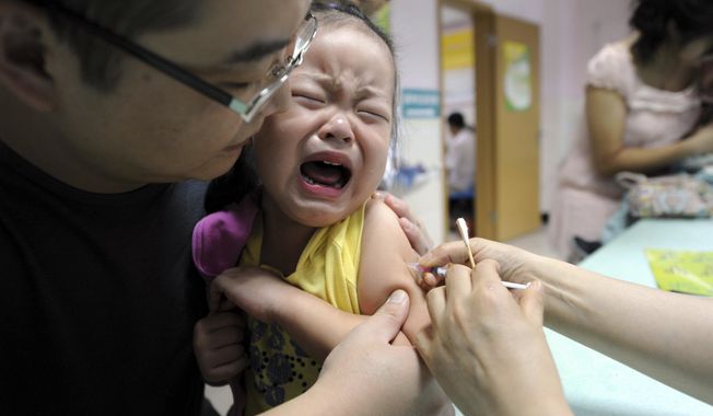 A child cries while receiving a shot of measles vaccine at a health station. (Chinatopix via AP)