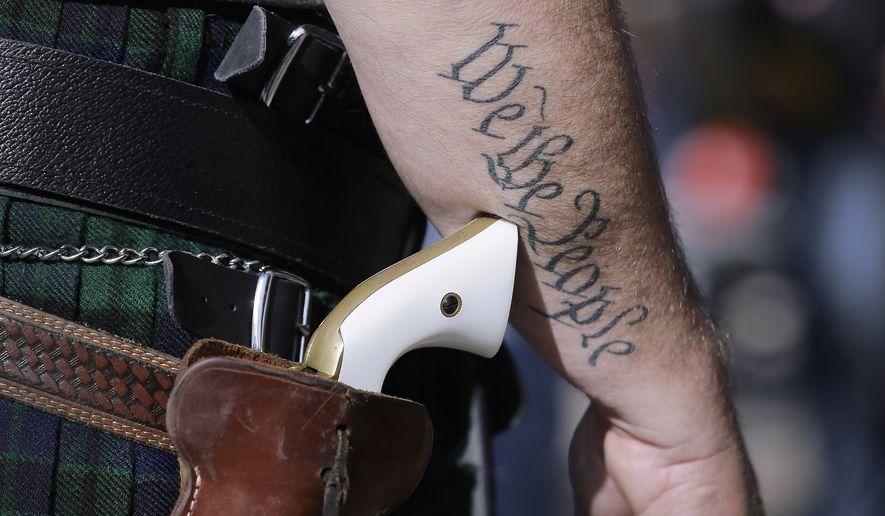 In this Jan. 26, 2015 file photo, a supporter of open carry gun laws, wears a pistol as he prepares for a rally in support of open carry gun laws at the Capitol, in Austin, Texas. (AP Photo/Eric Gay, File)