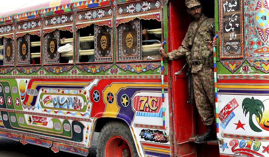 A Pakistani soldier stands guard in a bus carrying election staff and polling related material to stations in Karachi, Pakistan, Tuesday, July 24, 2018. As Pakistan prepares to make history Wednesday by electing a third straight civilian government, rights activists, analysts and candidates say the campaign has been among its dirtiest ever, imperiling the country's wobbly transition to democratic rule.(AP Photo/Shakil Adil)