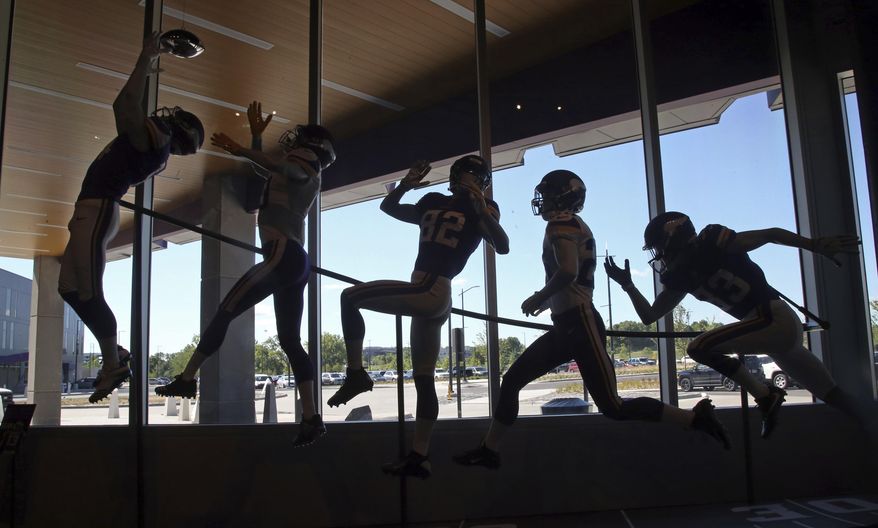 Lifesize replicas of Minnesota Vikings receivers, including last season's dramatic touchdown catch by Stefon Diggs, left, are included at the new Vikings Museum at the NFL football team's complex Tuesday, July 24, 2018, in Eagan, Minn., where training camp officially opens Wednesday for rookies. (AP Photo/Jim Mone)