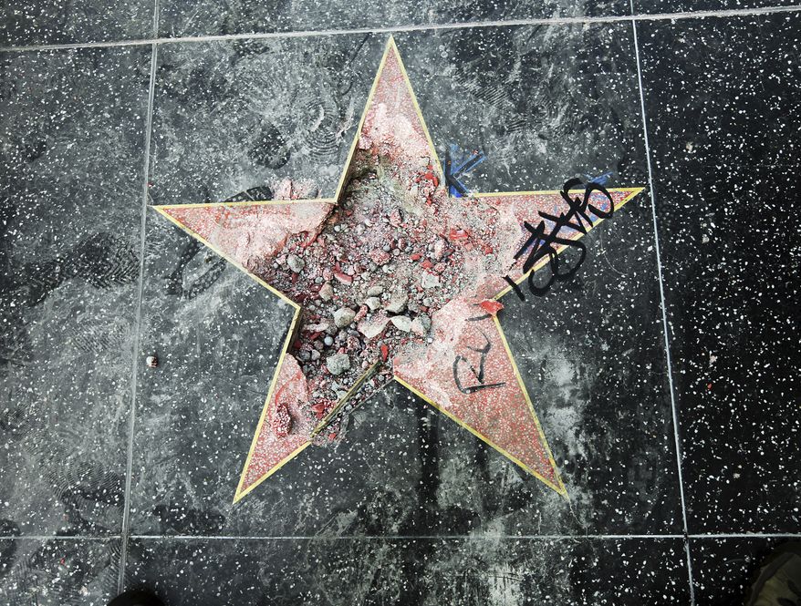This photo shows Donald Trump's star on the Hollywood Walk of Fame that was vandalized Wednesday, July 25, 2018, in Los Angeles. Los Angeles police Officer Ray Brown said the vandalism was reported early Wednesday and someone was subsequently taken into custody. Authorities said a pickax was used in the vandalism. (AP Photo/Reed Saxon)