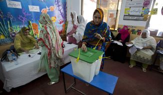 A Pakistani woman casts her vote at a polling station for the parliamentary elections in Islamabad, Pakistan, Wednesday, July 25, 2018. After an acrimonious campaign, polls opened in Pakistan on Wednesday to elect the country&#x27;s third straight civilian election, a first for this majority Muslim nation that has been directly or indirectly ruled by its military for most of its 71-year history. (AP Photo/B.K. Bangash)