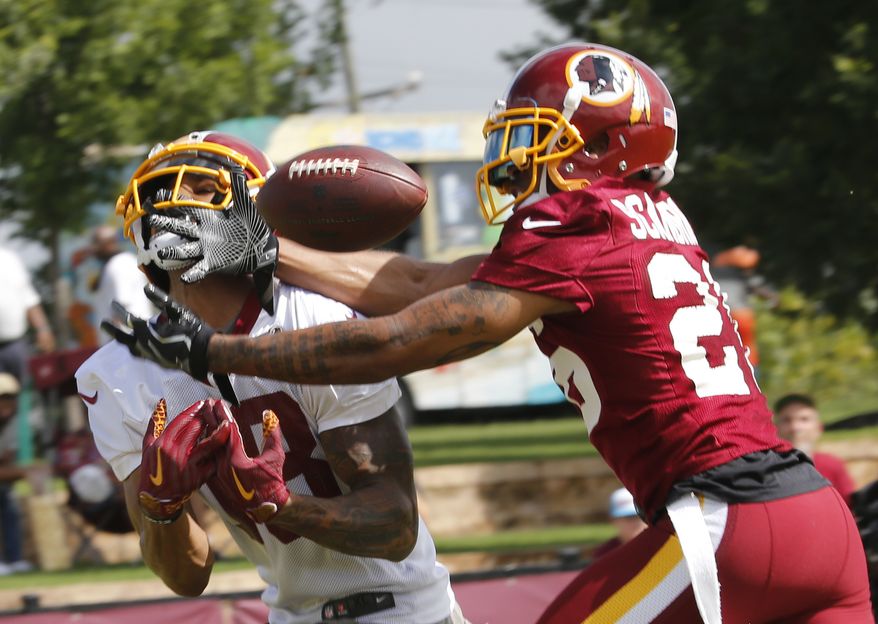 Washington Redskins cornerback Orlando Scandrick, right, breaks up a pass intended for wide receiver Josh Doctson at NFL football training camp in Richmond, Va., Thursday, July 26, 2018. (AP Photo/Steve Helber)