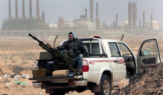 In this March 5, 2011, file photo, an anti-government rebel sits with an anti-aircraft weapon in front an oil refinery in Ras Lanouf, eastern Libya. The United States France, Germany, Italy, Spain and Britain have called upon forces loyal to a Libyan general to withdraw from three eastern oil terminals seized earlier this week, in a statement Monday, Sept. 13, 2016. The oil-rich North African country slid into chaos after the 2011 uprising that toppled and killed Moammar Gadhafi. (AP Photo/Hussein Malla, File)