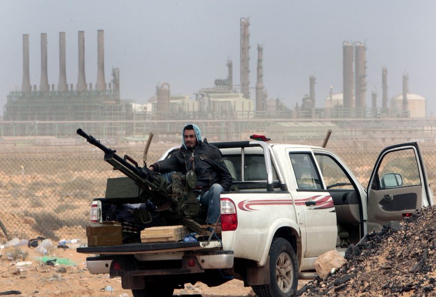 In this March 5, 2011, file photo, an anti-government rebel sits with an anti-aircraft weapon in front an oil refinery in Ras Lanouf, eastern Libya. The United States France, Germany, Italy, Spain and Britain have called upon forces loyal to a Libyan general to withdraw from three eastern oil terminals seized earlier this week, in a statement Monday, Sept. 13, 2016. The oil-rich North African country slid into chaos after the 2011 uprising that toppled and killed Moammar Gadhafi. (AP Photo/Hussein Malla, File)