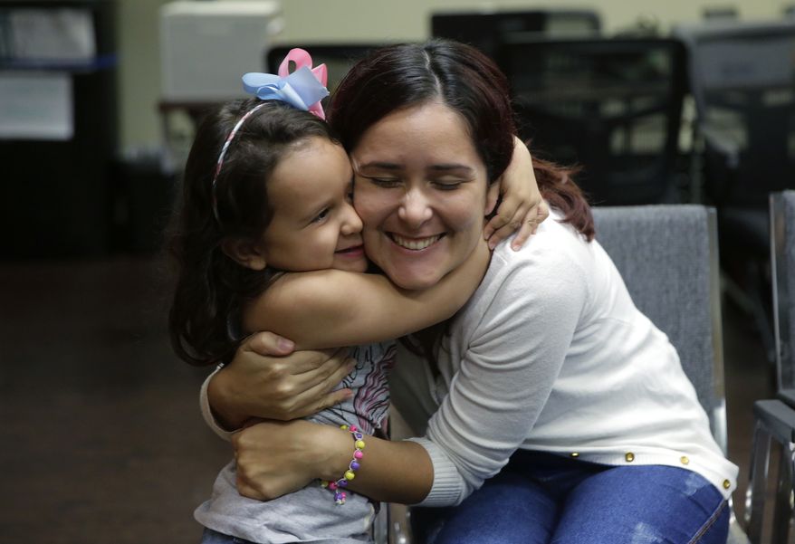 Immigrants seeking asylum Natalia Oliveira da Silva and her daughter, Sara, 5, hug as they wait at a Catholic Charities facility, Monday, July 23, 2018, in San Antonio. Since their separation in late May, the girl had been at a shelter for immigrant minors in Chicago, while Oliveira was taken to various facilities across Texas. As the government faces a fast-approaching Thursday deadline to reunite hundreds of families, it is shifting the responsibility for their well-being to faith-based groups primarily in Texas and Arizona. (AP Photo/Eric Gay)
